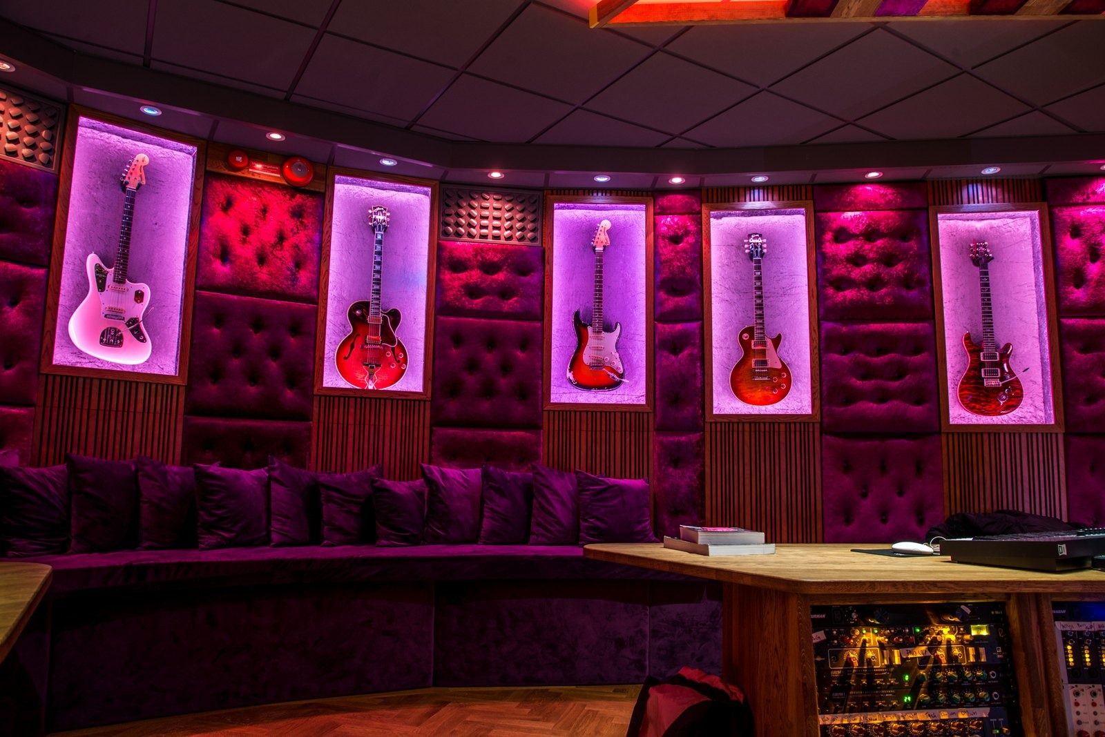 Spotify: Guitars in lit niches on a purple padded wall