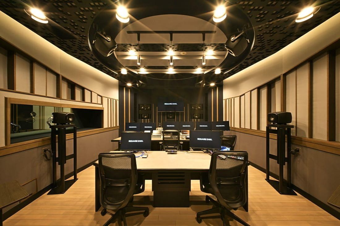 Square Enix: Mixing room with a large console, monitors and wood-panelled walls under warm spotlights
