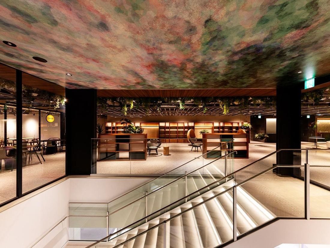 Square Enix: Open floor with a dark ceiling, a staircase and bookshelves