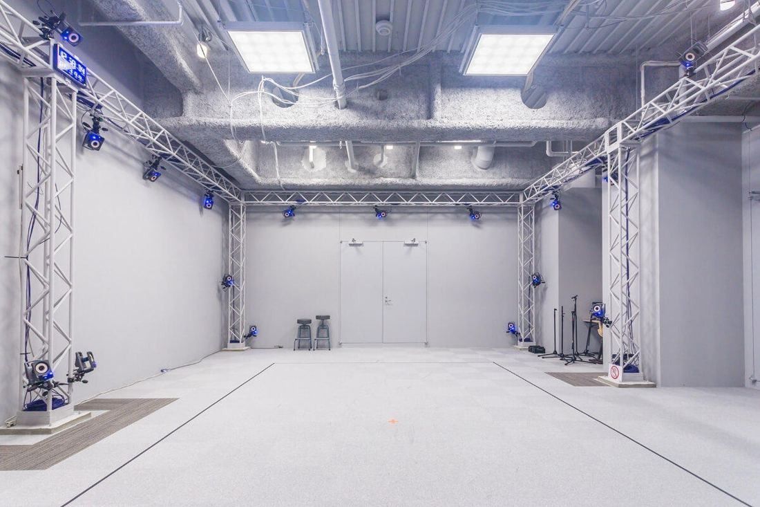 Square Enix: White studio with metal trusses holding cameras around an open floor