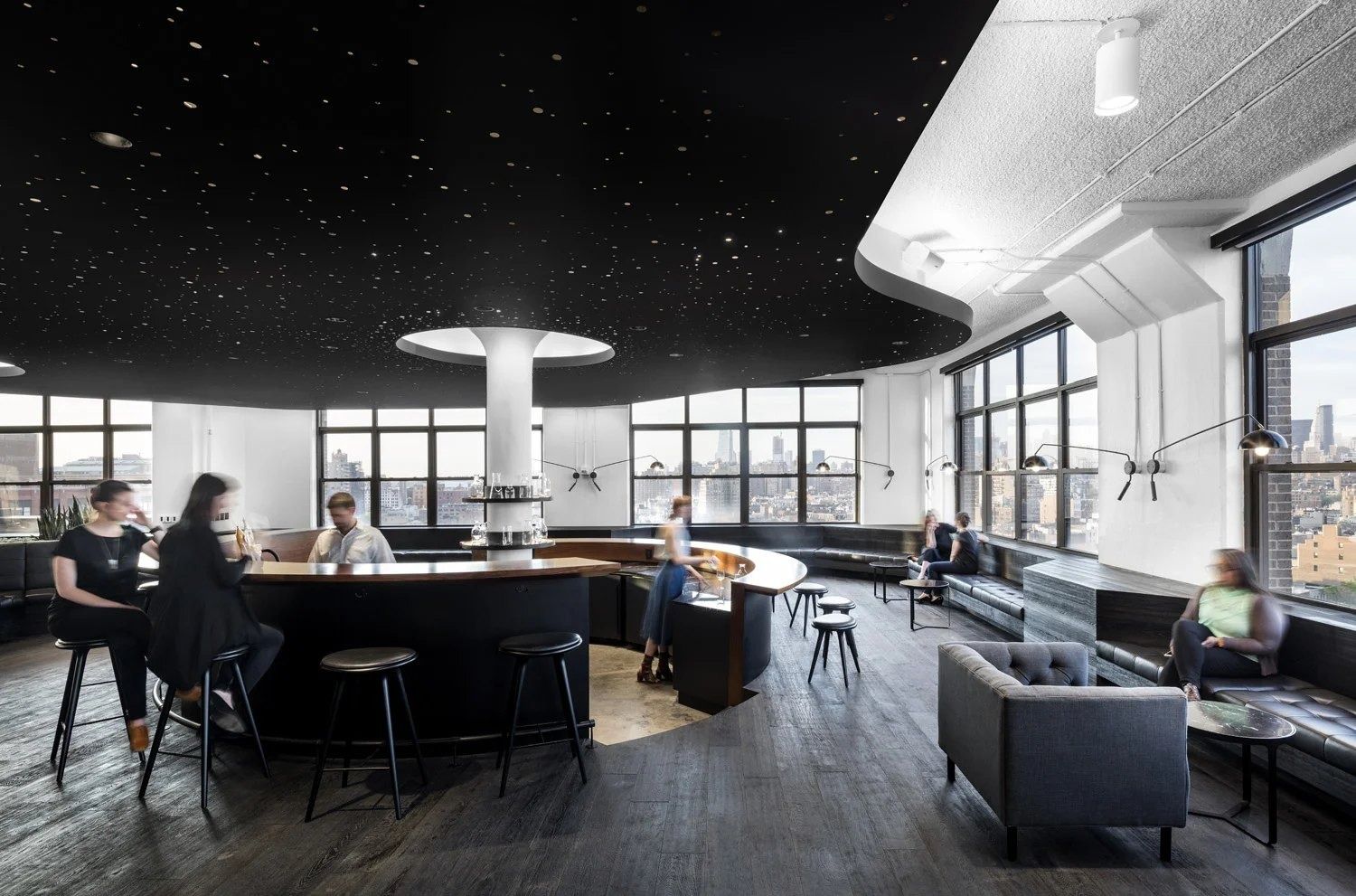 Squarespace: Curved bar under a black ceiling dotted with small lights, with stools, sofas and windows looking over the city