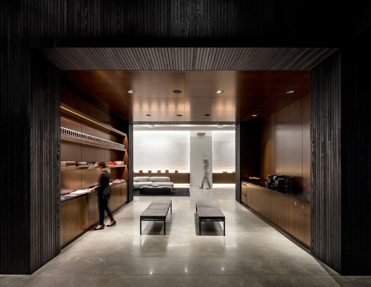 Squarespace: Dark wood-lined vestibule opening onto a bright room with benches and shelving