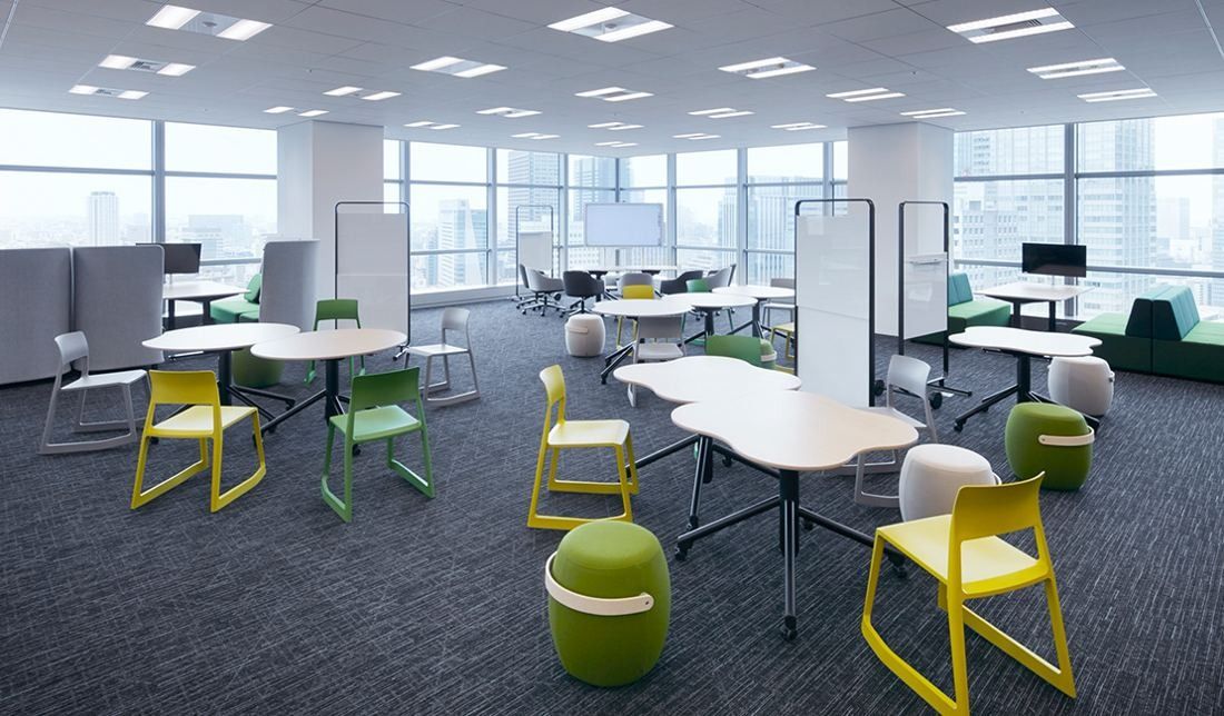 Sumitomo Corporation: Bright area with white tables, green chairs and whiteboards