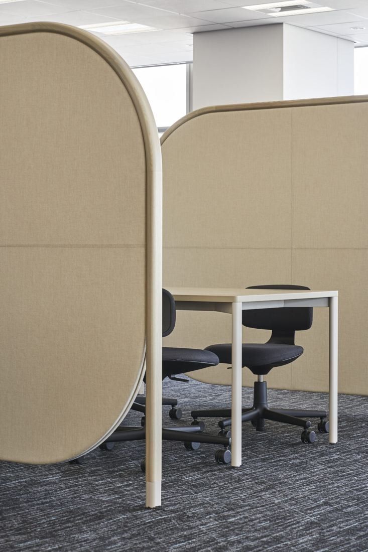Sumitomo Corporation: Curved light wood booth screens around a small desk and chairs