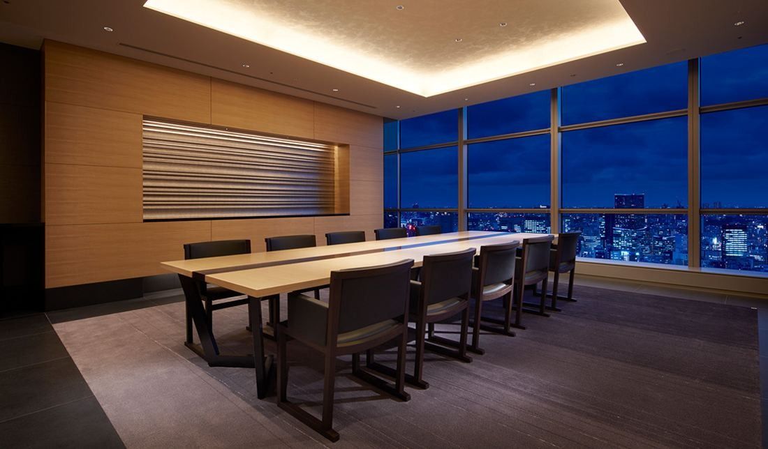 Sumitomo Corporation: Dark wood meeting room with a long table and a night city view