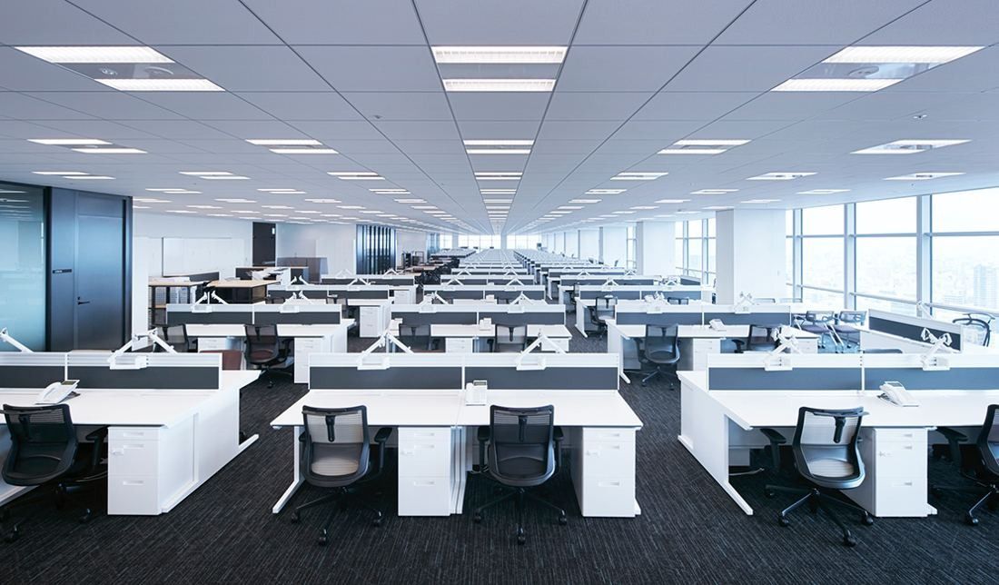 Sumitomo Corporation: Large open-plan office with rows of white desks and grey chairs