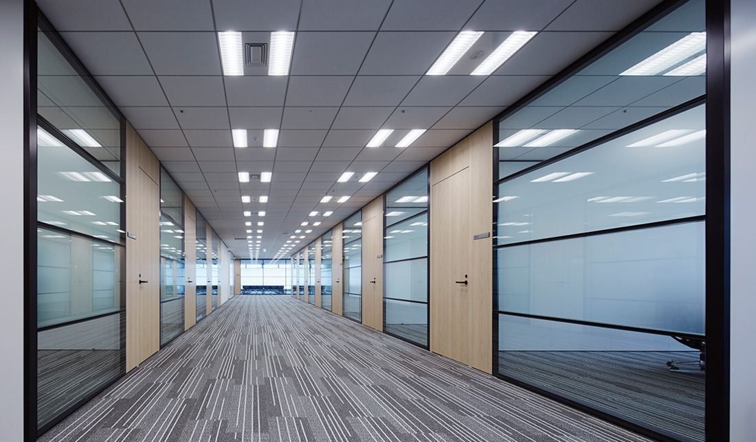 Sumitomo Corporation: Long carpeted corridor between glass-walled rooms