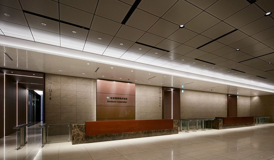 Sumitomo Corporation: Long reception counter in a bright lobby with stone walls