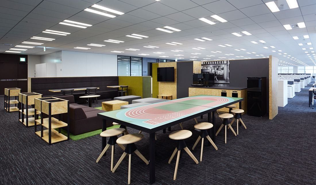 Sumitomo Corporation: Workspace with a colourful long table, wooden stools and shelving