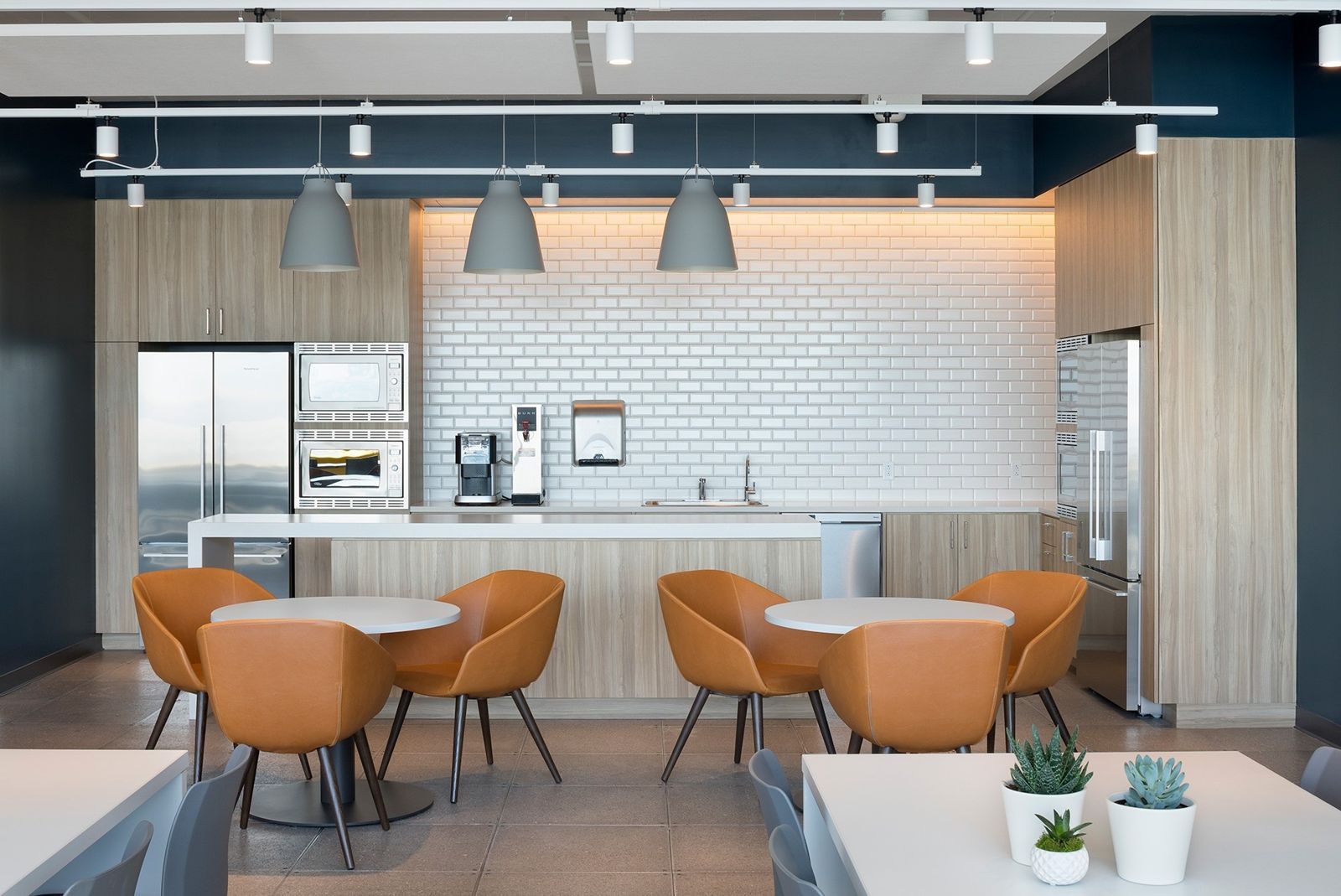 Sun Life: A kitchen with orange chairs and round tables
