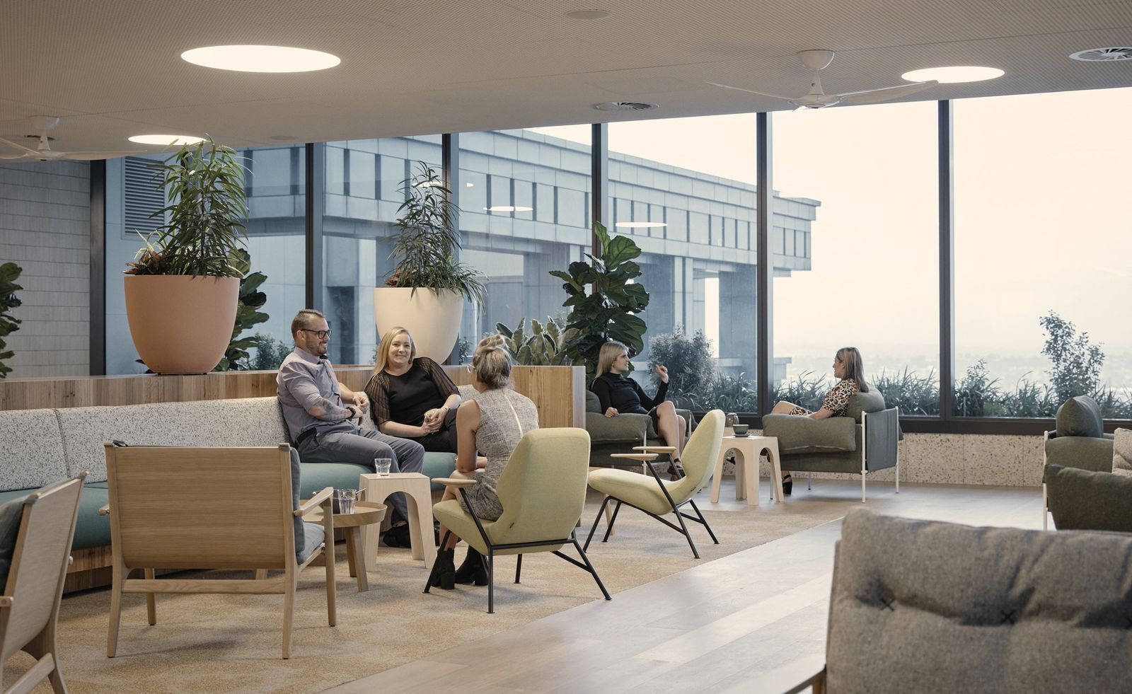 Suncorp: People chatting on sofas among large potted plants by tall windows