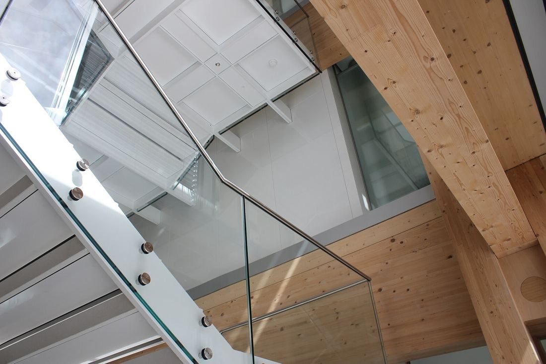 The Swatch Group: Looking up at glass-railed stair flights and laminated timber beams