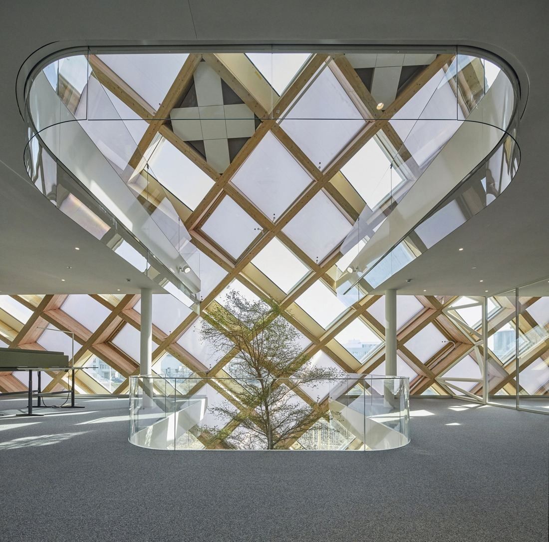 The Swatch Group: Oval opening in a white floor looking up to a wooden diamond lattice, with a tree growing through