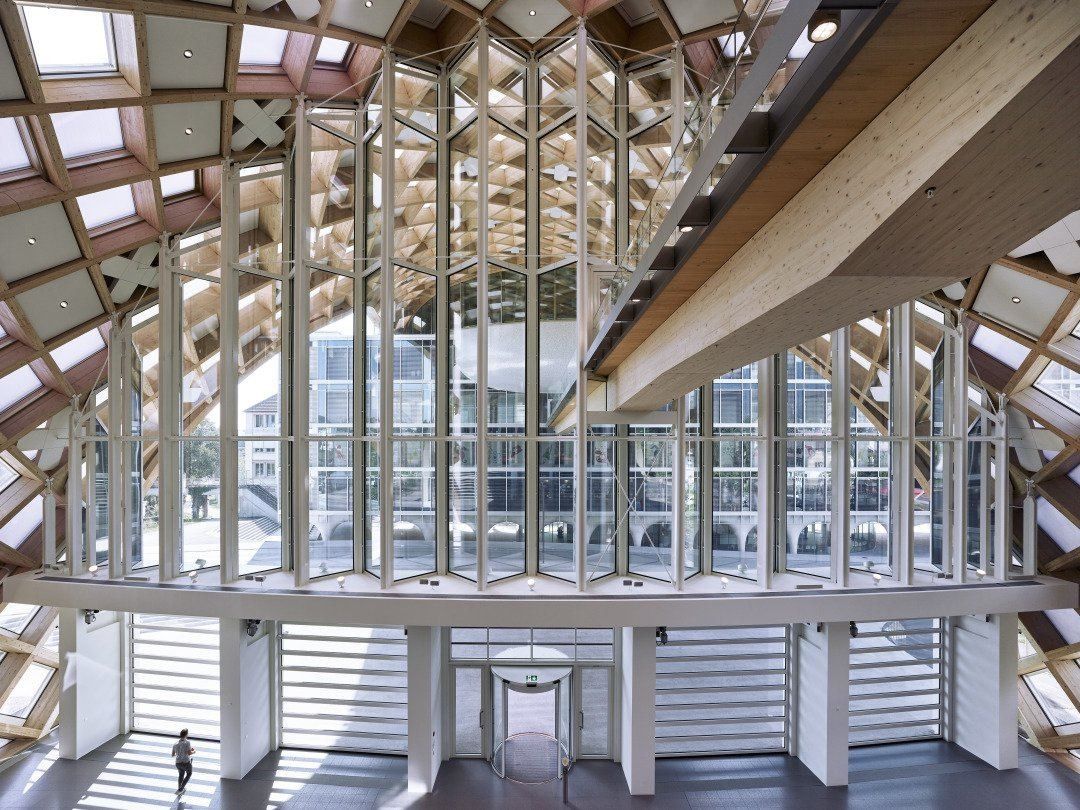 The Swatch Group: Tall glazed end wall seen from an upper level, framed by wooden beams and a timber walkway