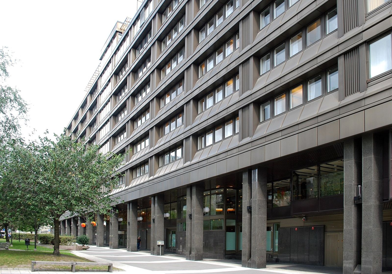 A long dark office building with a row of trees