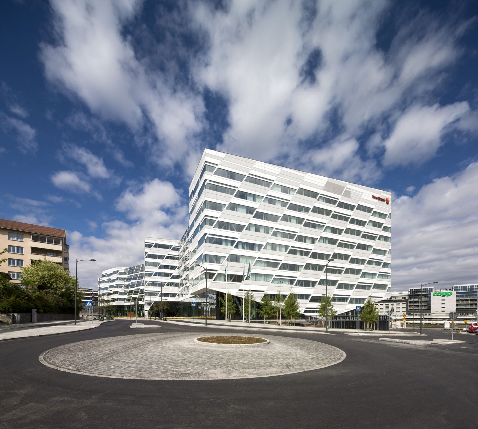 Swedbank: A stepped white building beyond a roundabout
