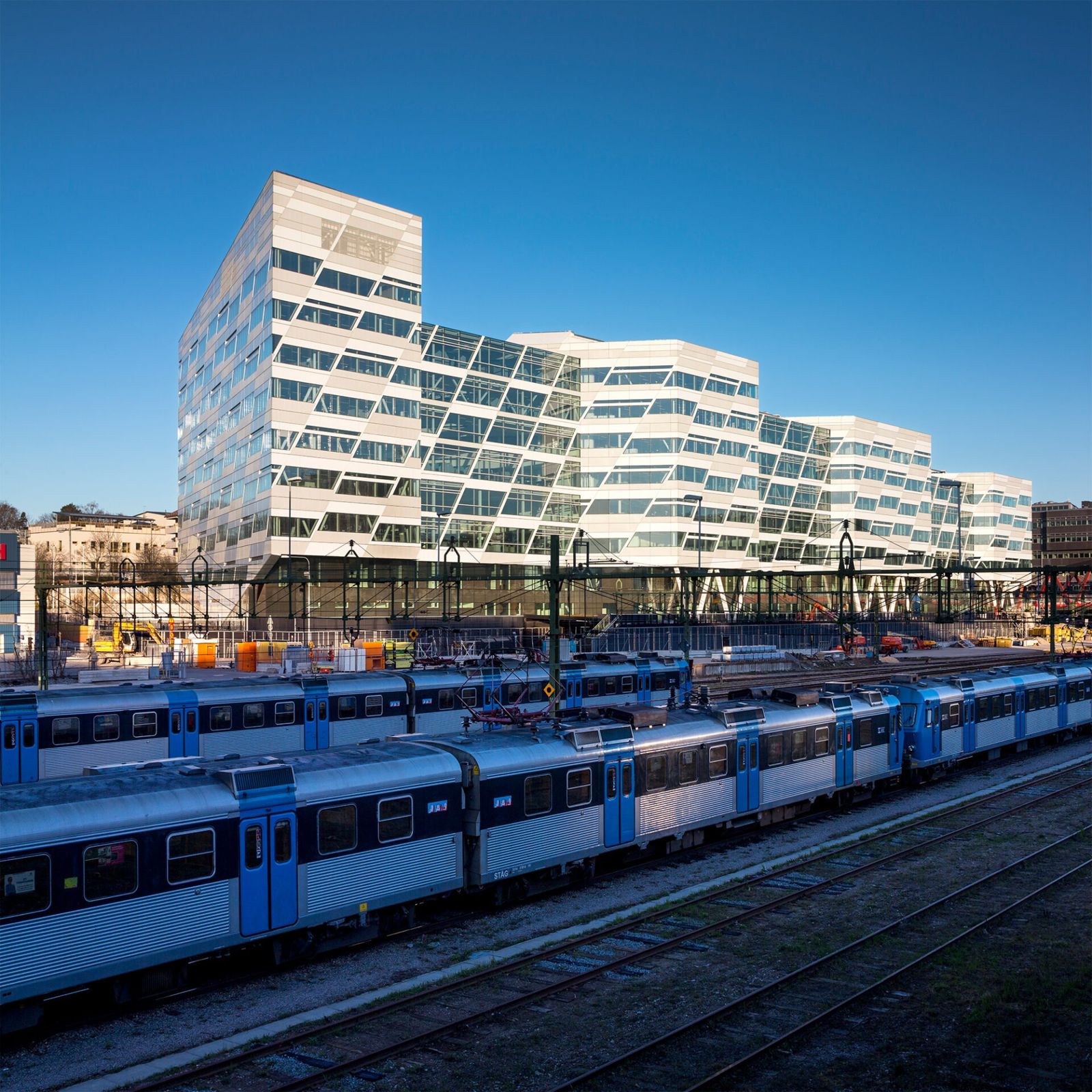 Swedbank: A white zig-zag building behind parked blue trains