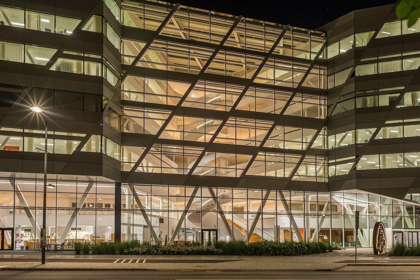 Swedbank: Lit glass facade with diagonal structure at night