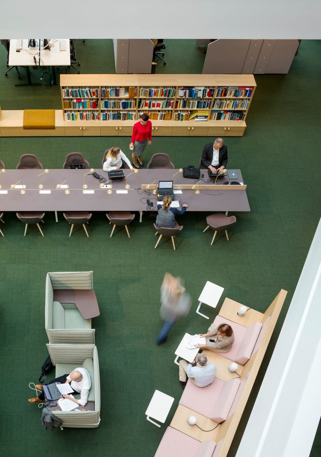 Swedbank: Long work tables and a library wall seen from above