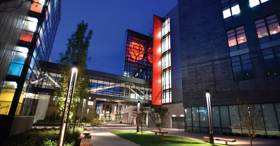 T-Mobile US: Path between buildings at night with a lit skybridge