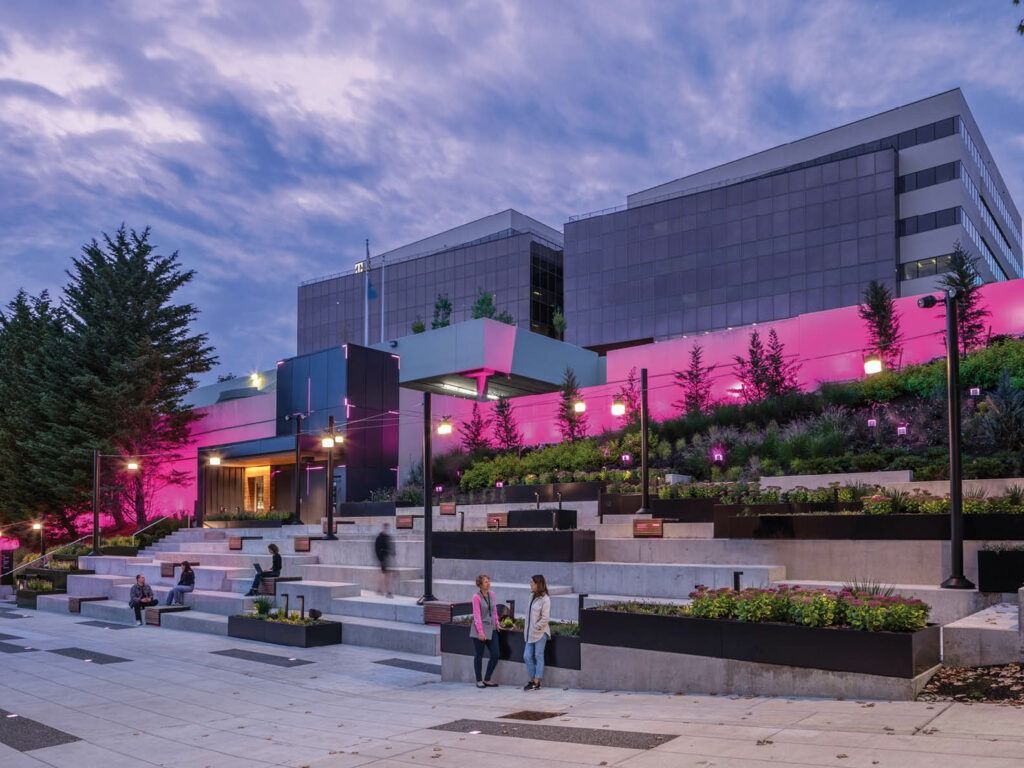 T-Mobile US: Steps and planters below office buildings lit in magenta
