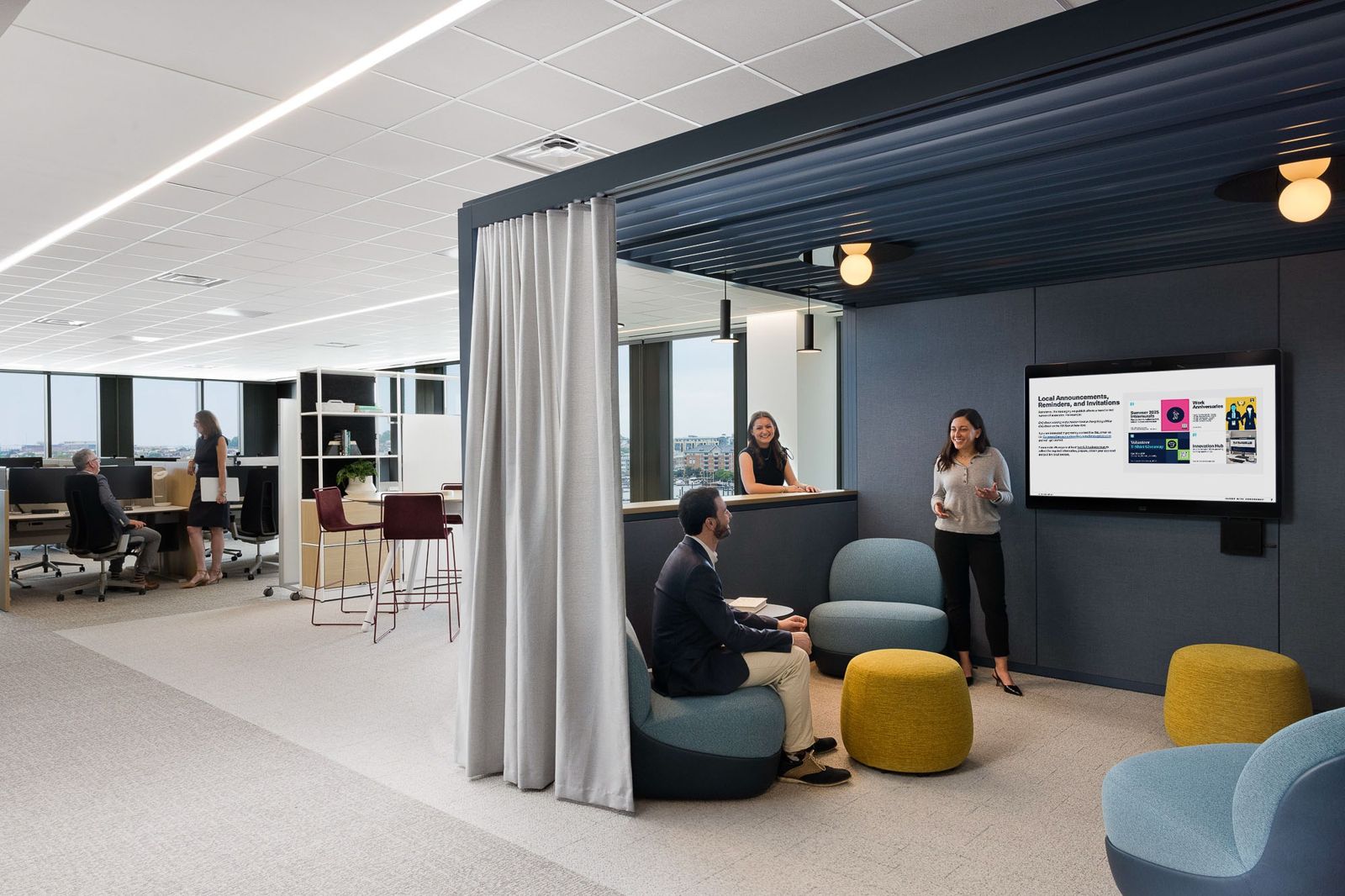 T. Rowe Price: A curtained team booth with sofas and a wall screen