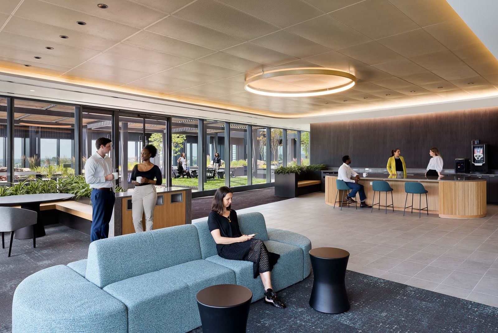 T. Rowe Price: A lounge with a circular ceiling light and a coffee bar by the windows