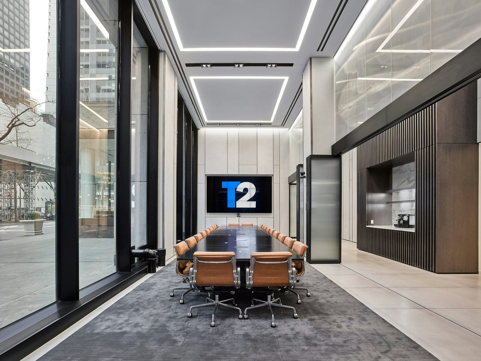 Take-Two Interactive: Glass-walled meeting room with a long table and leather chairs, a screen on the far wall