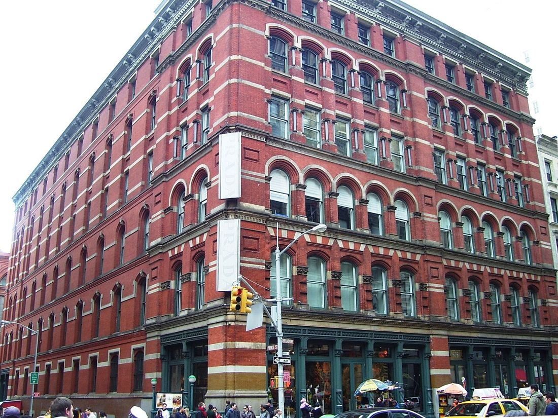 Red cast-iron and brick corner building at Broadway and Prince Street