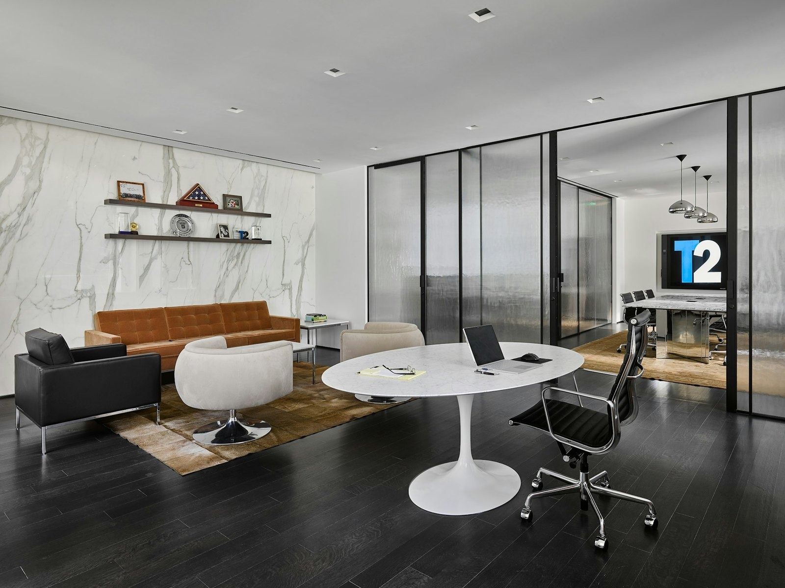 Take-Two Interactive: Lounge area with a sofa, armchairs and a white round table in front of marble walls