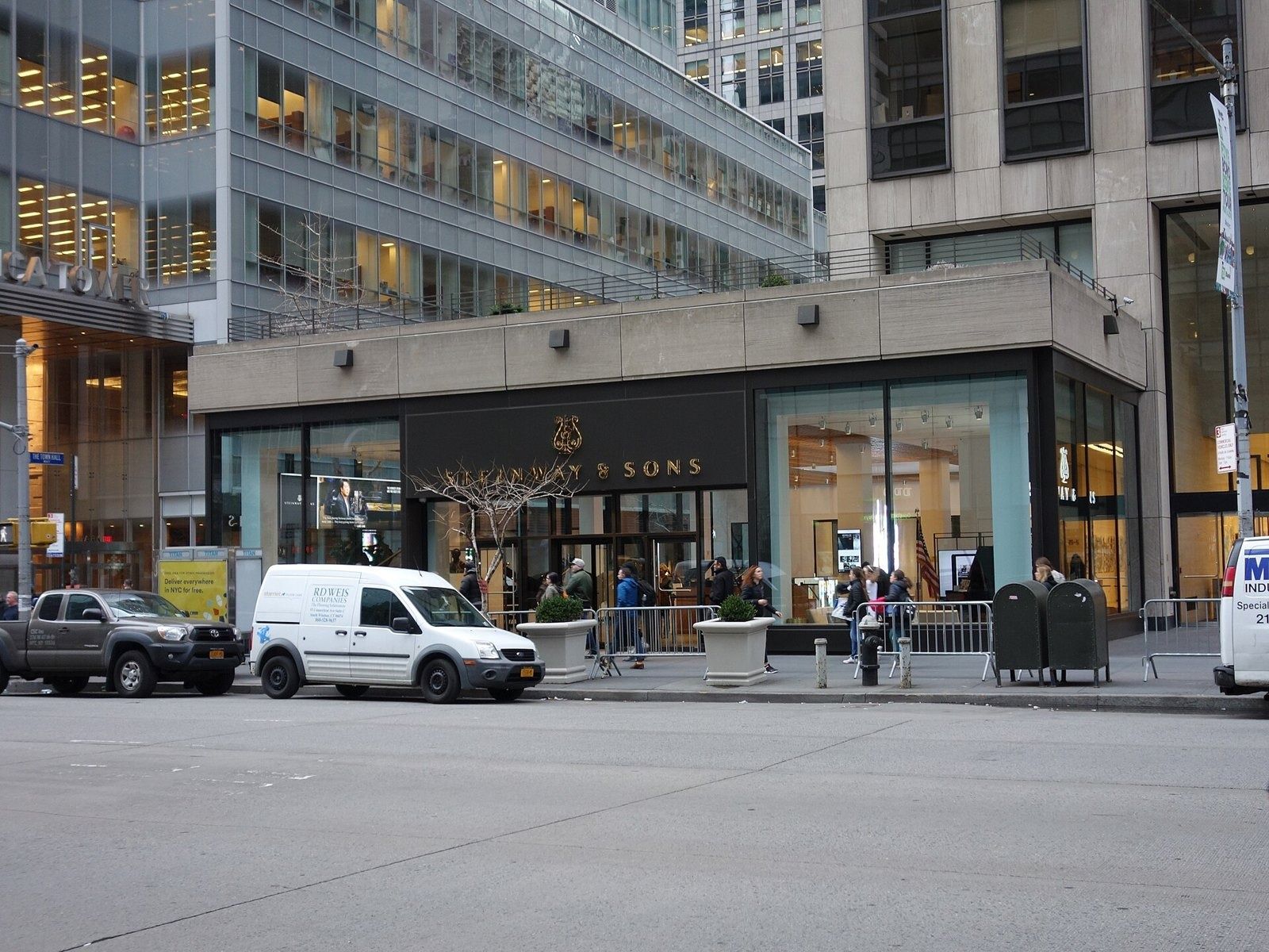 Take-Two Interactive: Low glass storefront building at the base of a tower, with vans parked in front