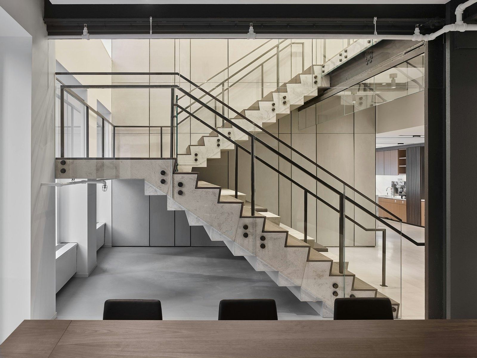 Take-Two Interactive: Open steel and wood staircase connecting two floors behind a table