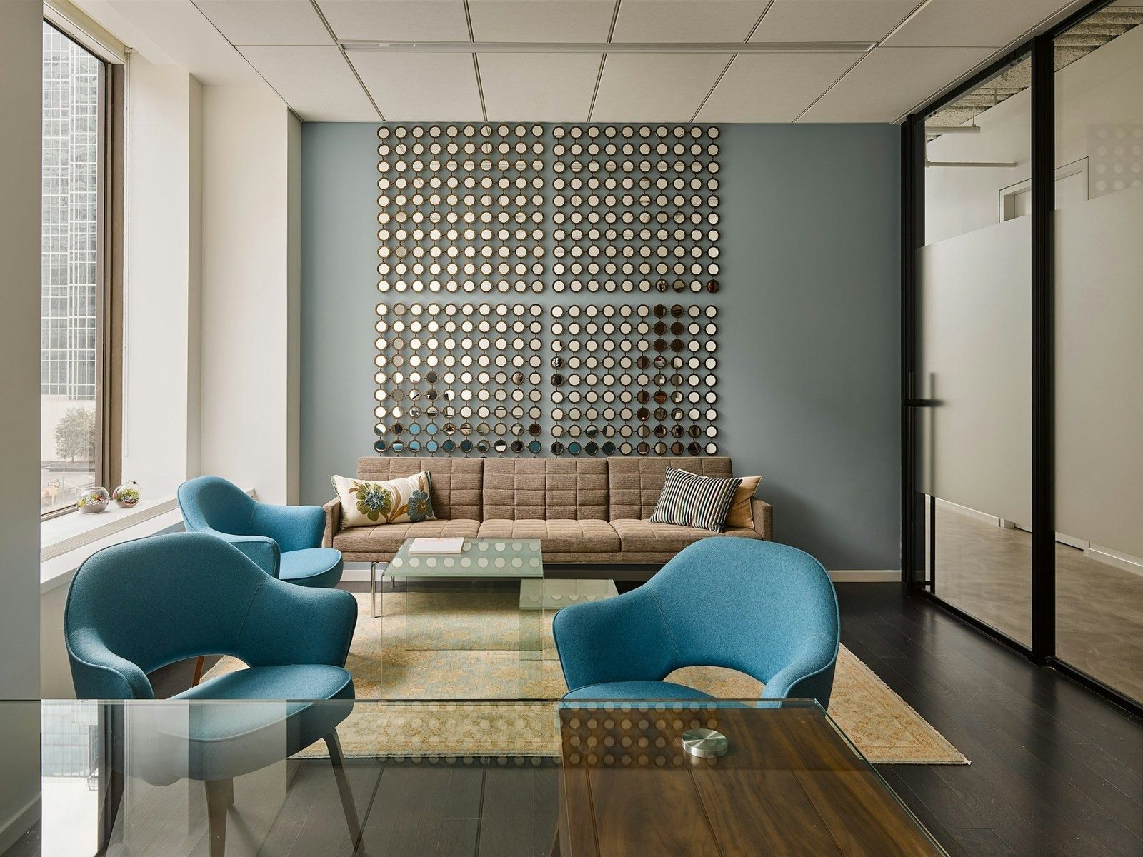 Take-Two Interactive: Small seating area with blue armchairs, a sofa and a decorative wall screen