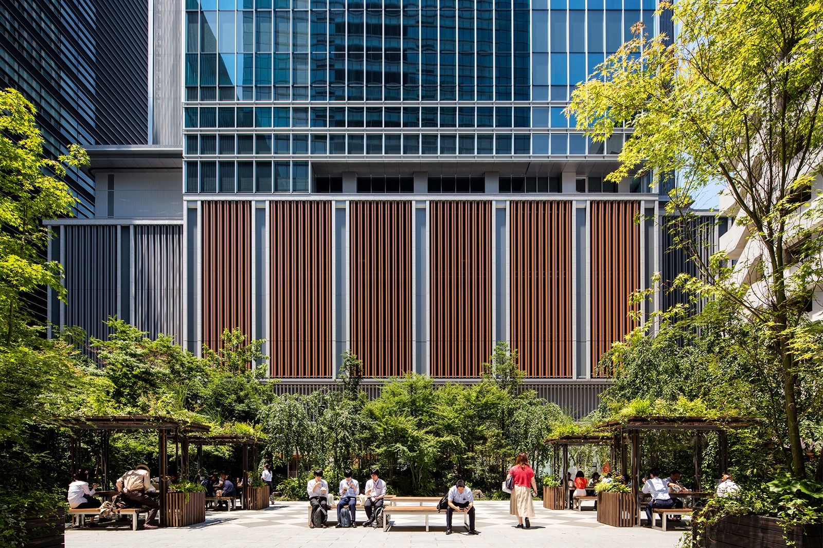 Takeda: Garden with trees and seating in front of timber louvres