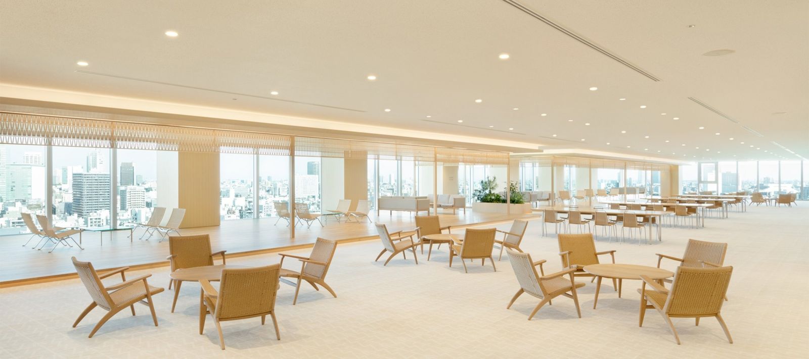 Takeda: Open floor with wooden lounge chairs and wide windows