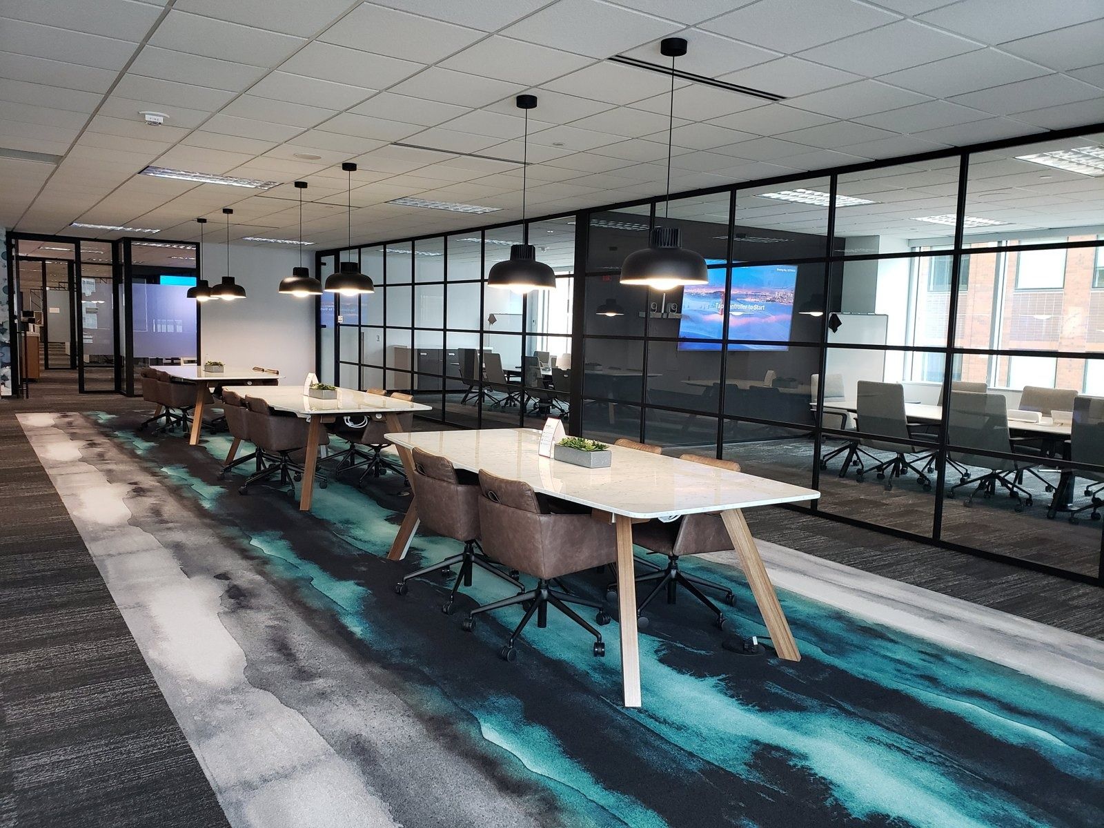 Target: Bookable team tables with pendant lights and a teal rug