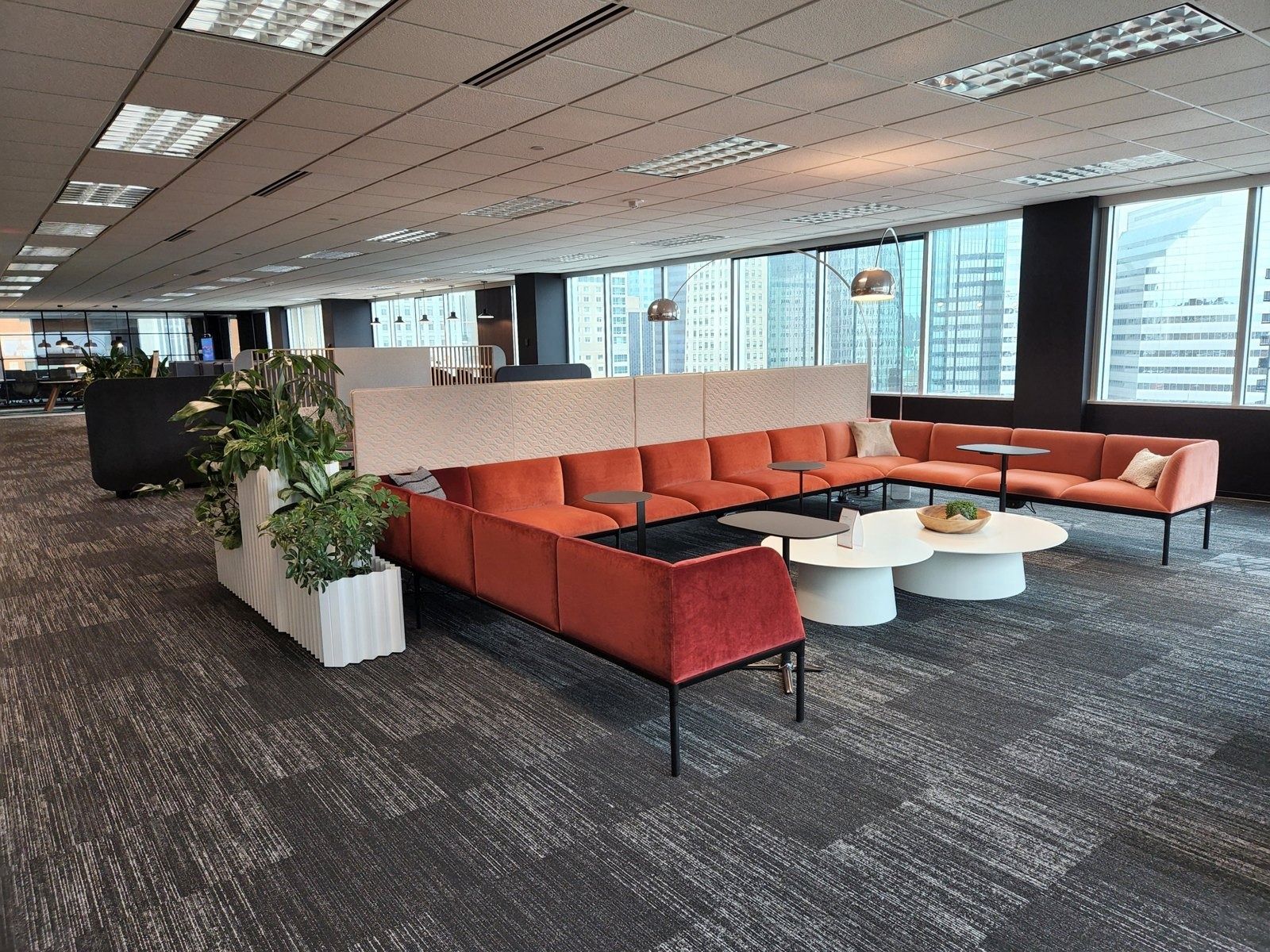 Target: Lounge with orange sofas and planters on a flex floor