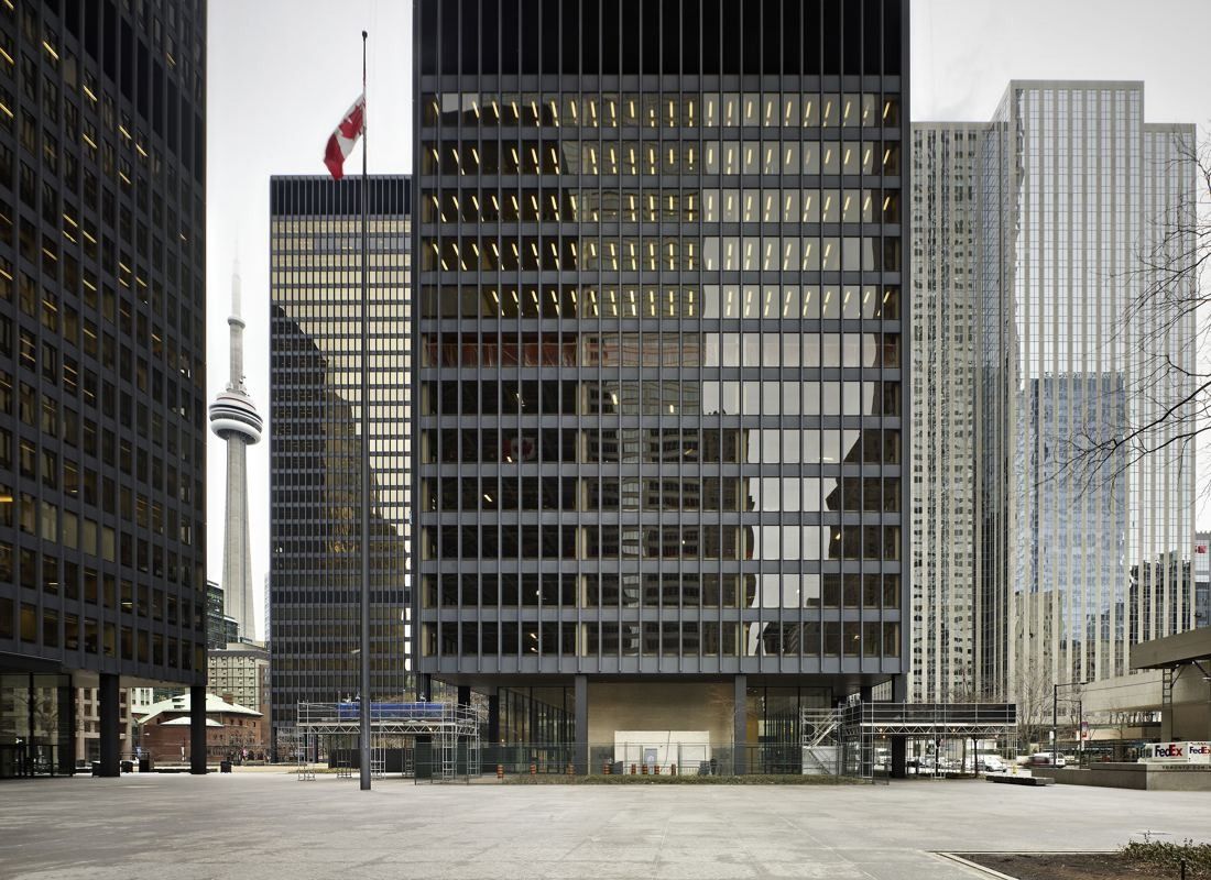 TD Bank Group (The Toronto-Dominion Bank): Black grid facade of a tower over an empty granite plaza, with the CN Tower in the distance