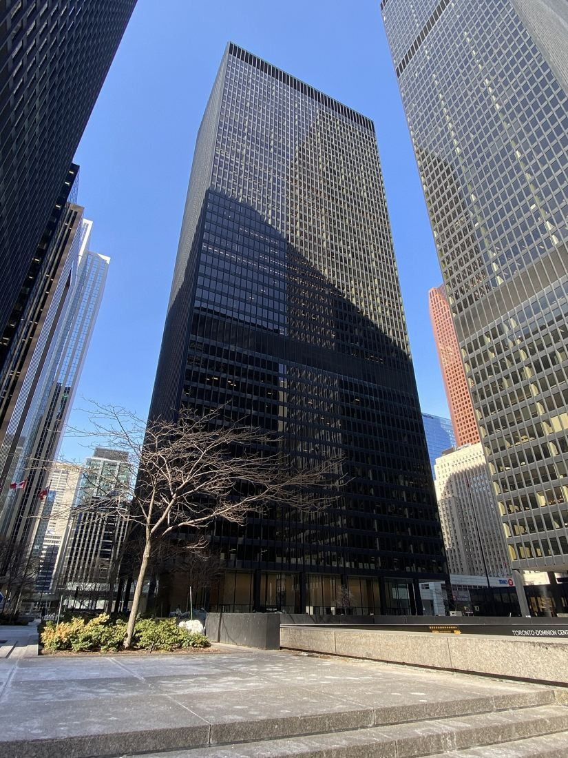 TD Bank Group (The Toronto-Dominion Bank): Black tower seen from a granite plaza on a sunny day