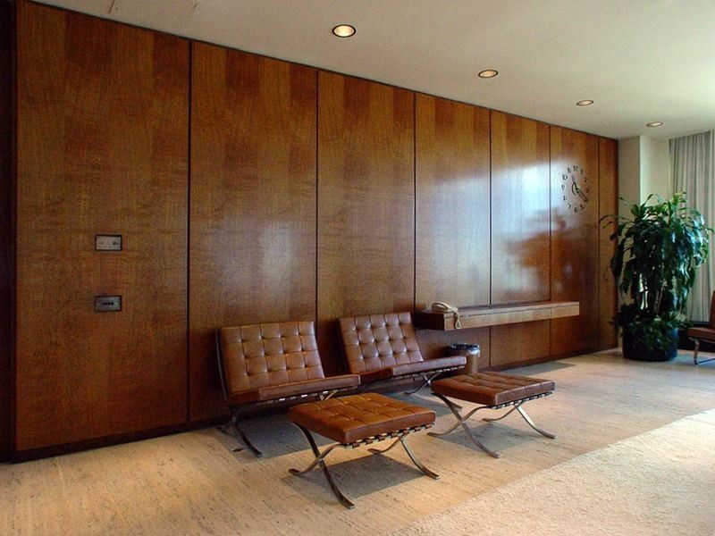 TD Bank Group (The Toronto-Dominion Bank): Leather Barcelona chairs and stools in a room with wooden wall panels