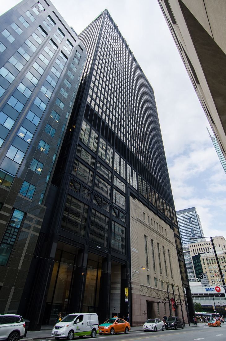 TD Bank Group (The Toronto-Dominion Bank): Tall black tower beside a street with parked cars