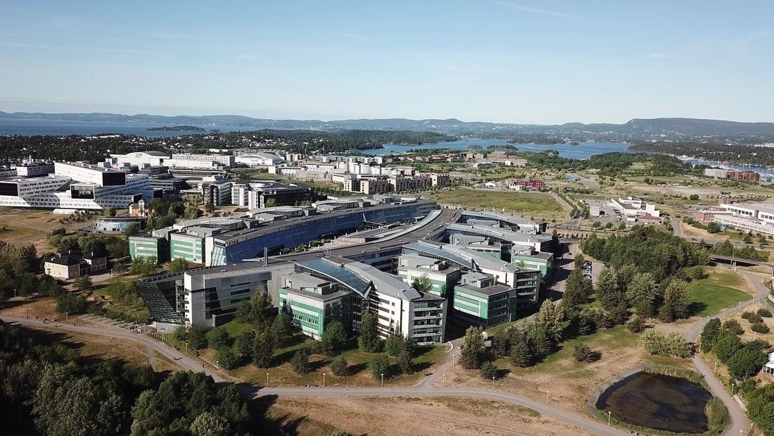 Telenor: Aerial view of the curved office complex among green fields and new buildings