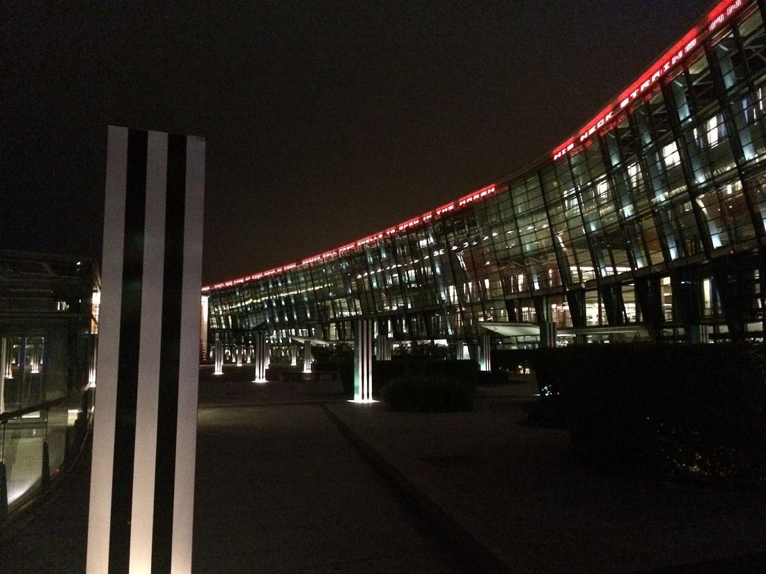 Telenor: Curved glass facade lit at night with a red light along the roof edge