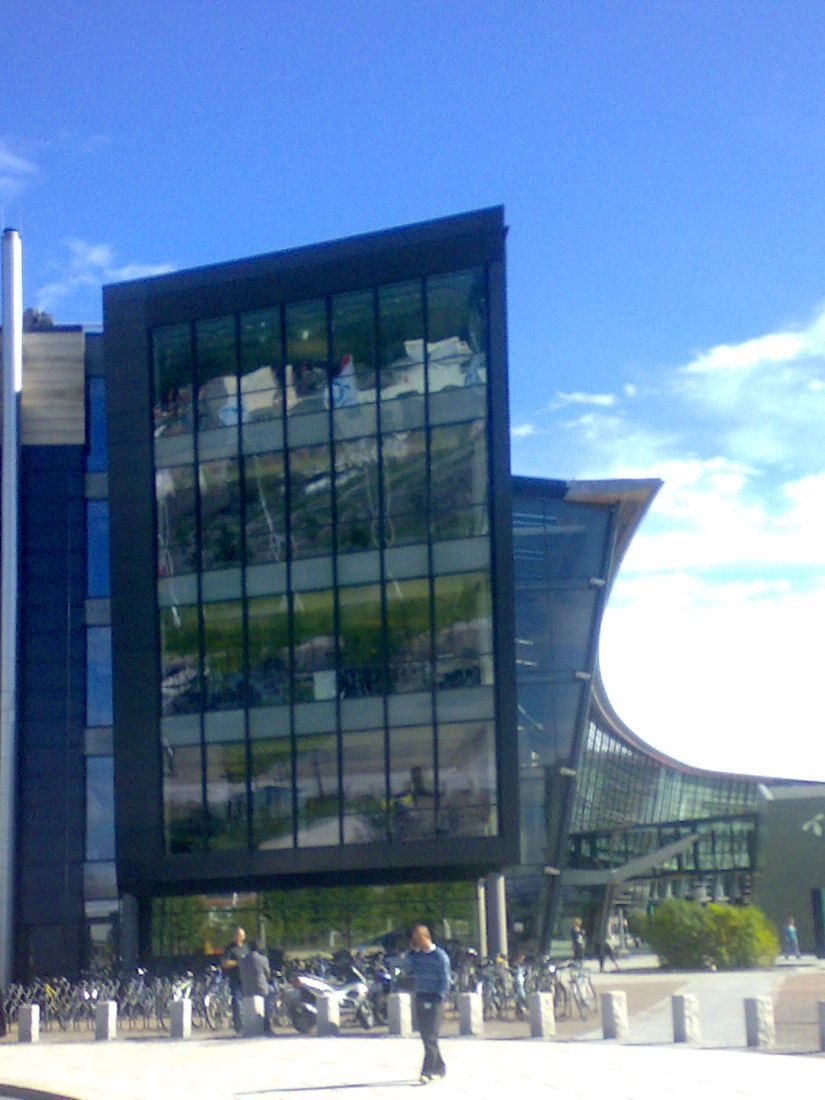 Telenor: Dark glass office block with a curved glass roof behind it