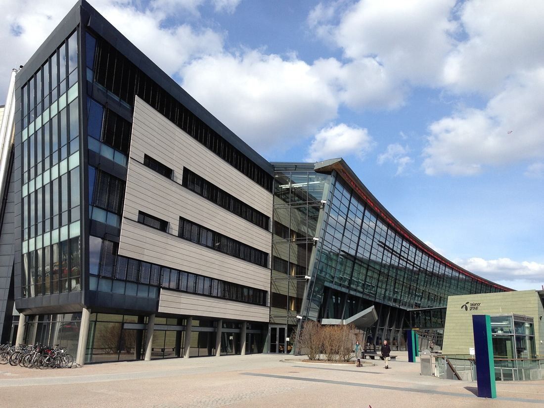 Telenor: Office wing with horizontal bands of windows beside a curving glass building