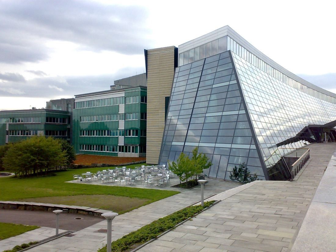 Telenor: Slanted glass building next to lawns and green-clad office wings