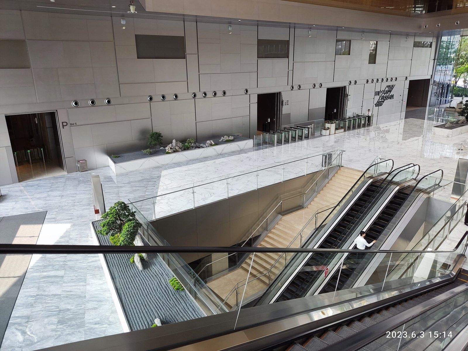Tencent: Escalators down into a large stone-clad lobby