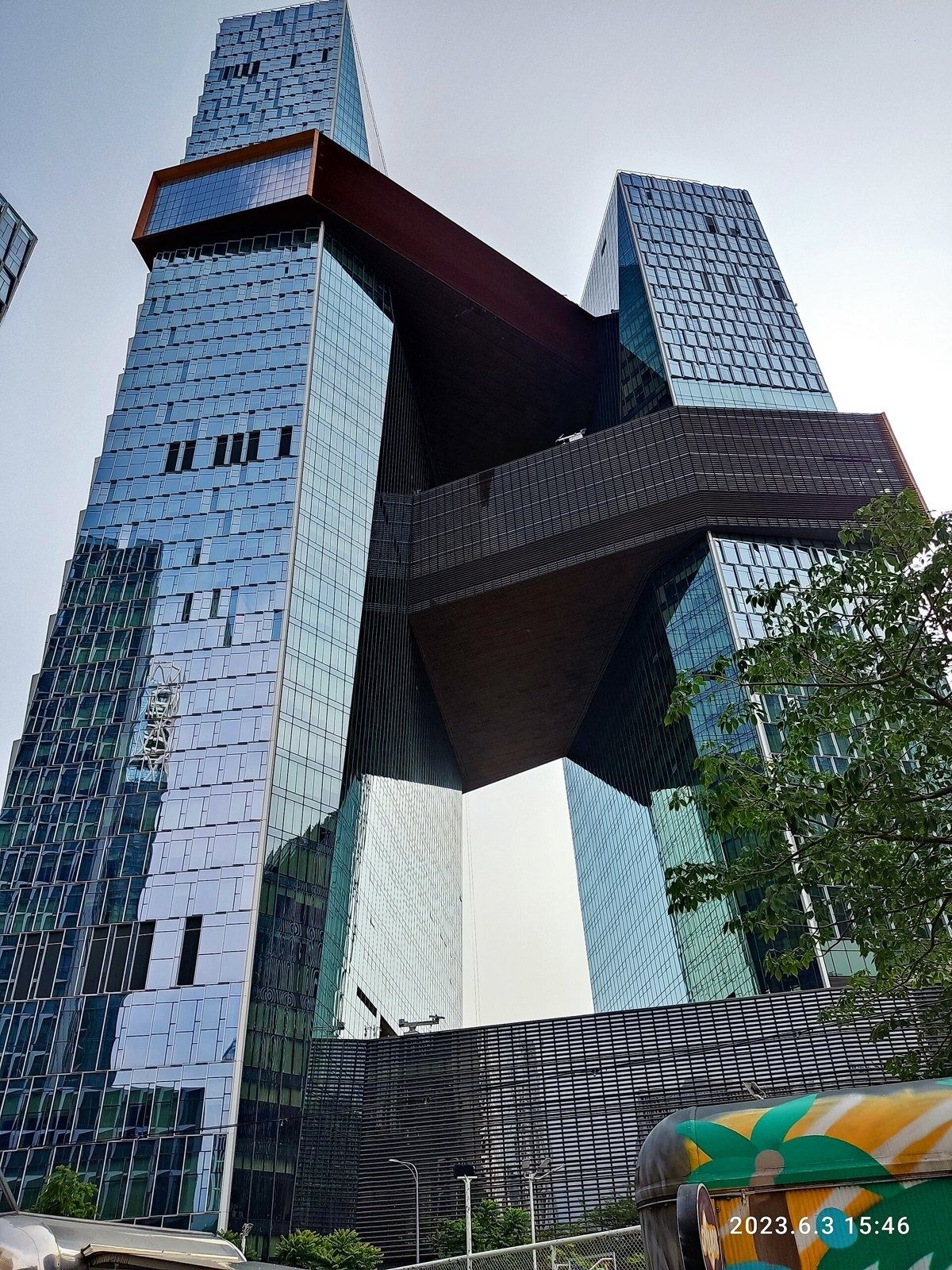 Tencent: Looking up at a dark sky bridge between two glass towers