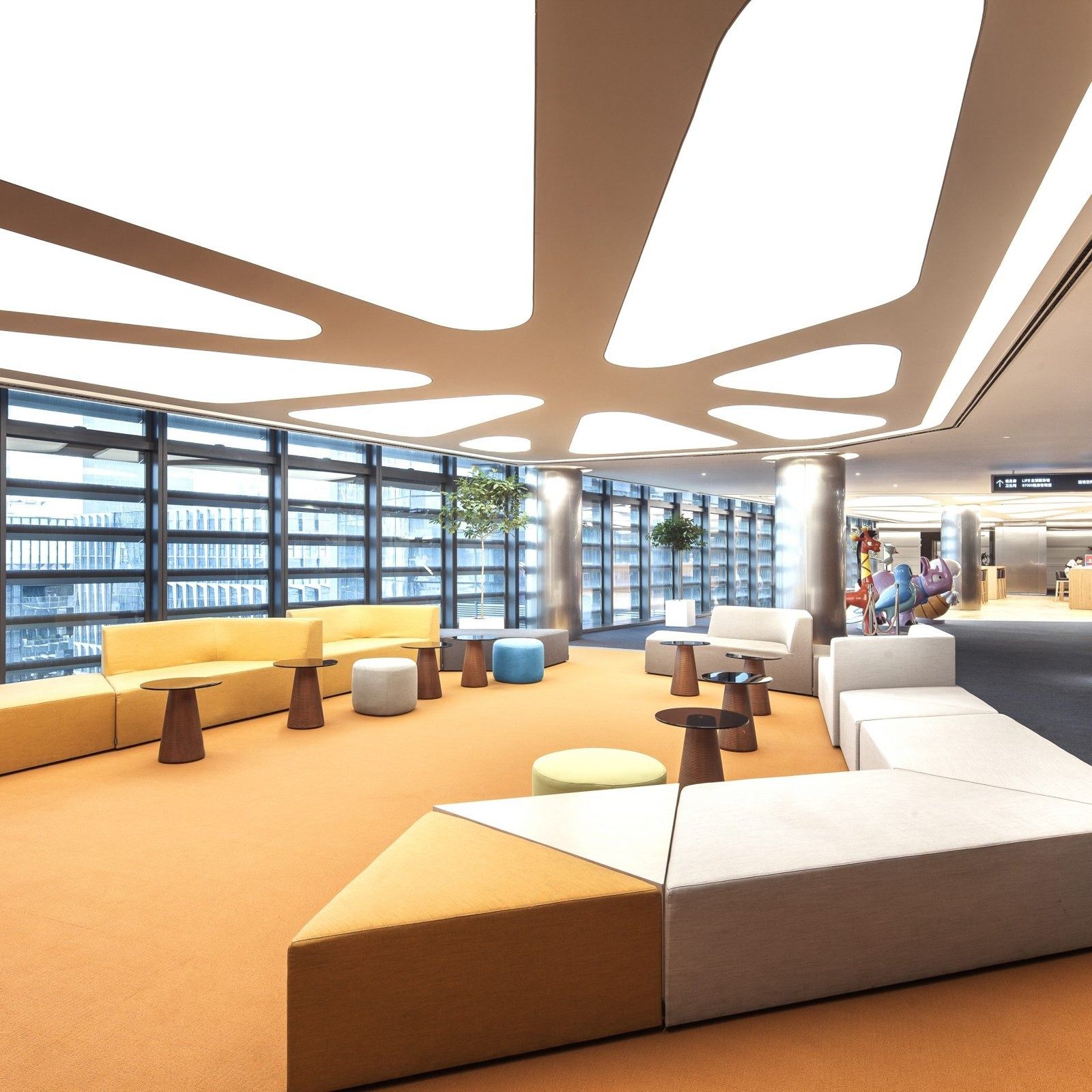 Tencent: Lounge with yellow and white sofas under a curving light ceiling