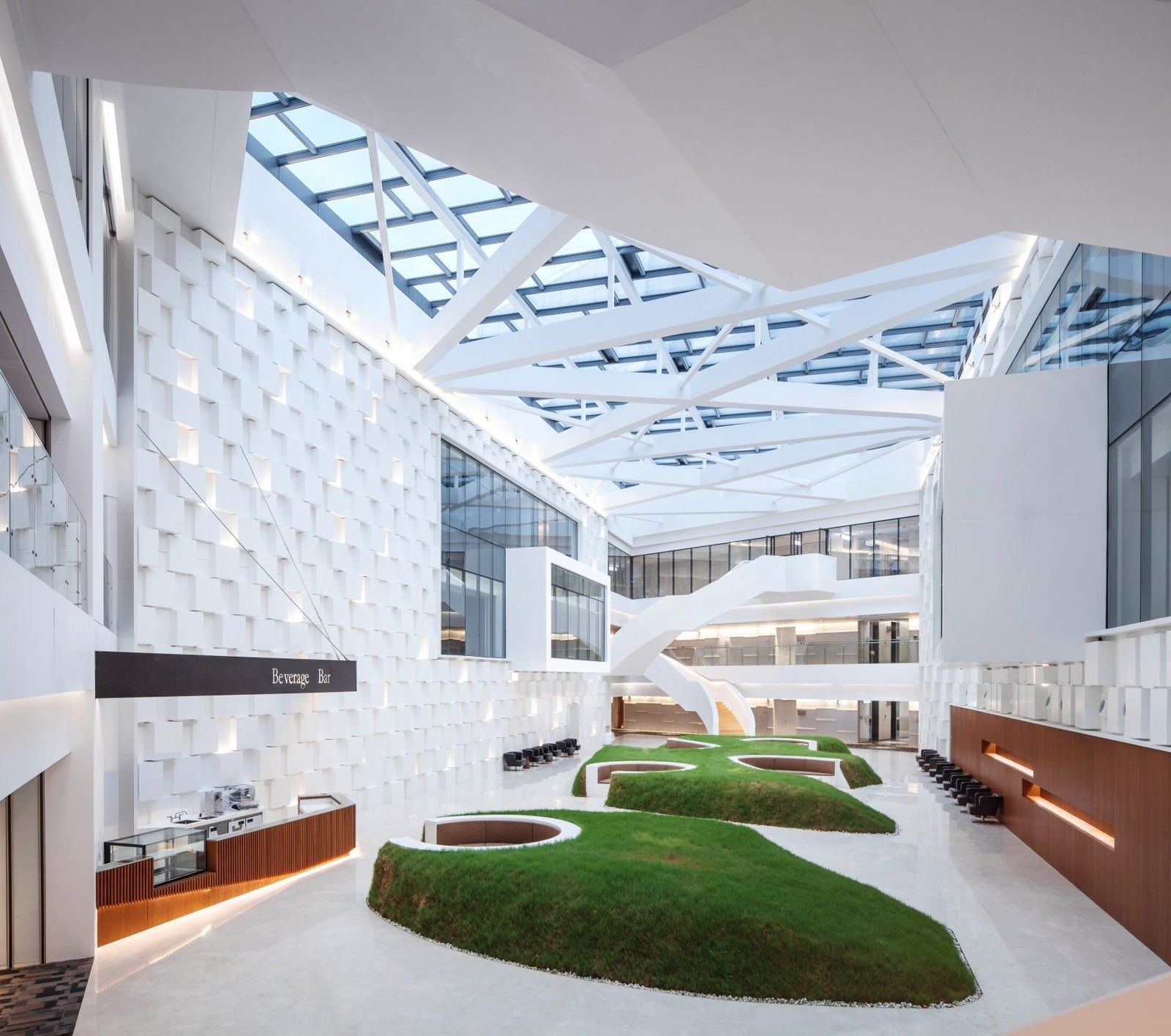 Tencent: Skylit atrium with white walls and grass-covered seating islands